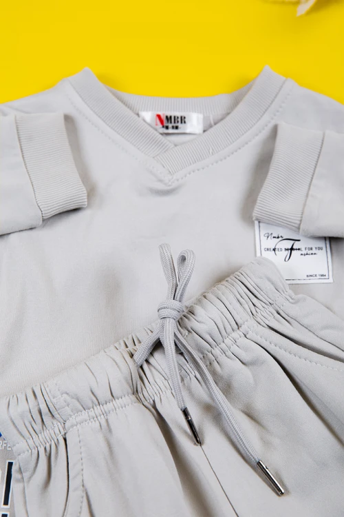 طقم بناتي شتوي قطعتين لون رصاصي بكتابات من الأمام و أكمام طويلة و رباط و زم من الخصر