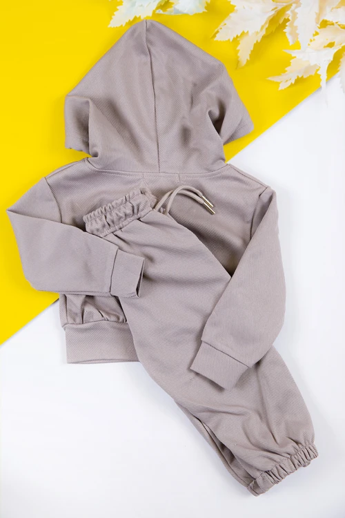 طقم بناتي شتوي قطعتين لون بيج بكتابات من الأمام و بقبعة رأس  و أكمام طويلة و رباط و زم من الخصر