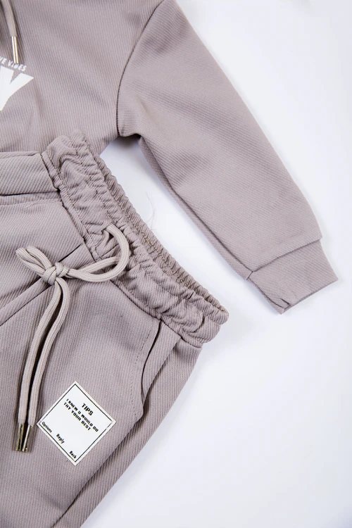 طقم بناتي شتوي قطعتين لون بيج بكتابات من الأمام و بقبعة رأس  و أكمام طويلة و رباط و زم من الخصر