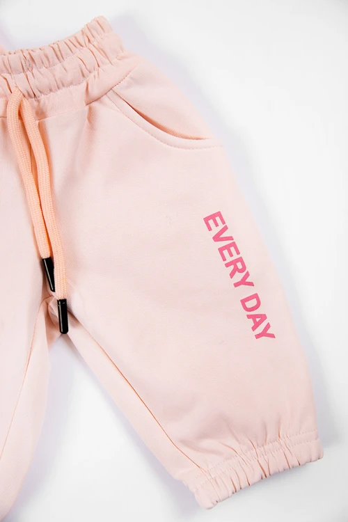 طقم بناتي شتوي قطعتين لون خربزي بكتابات من الأمام و بقبعة رأس  و أكمام طويلة و رباط و زم من الخصر