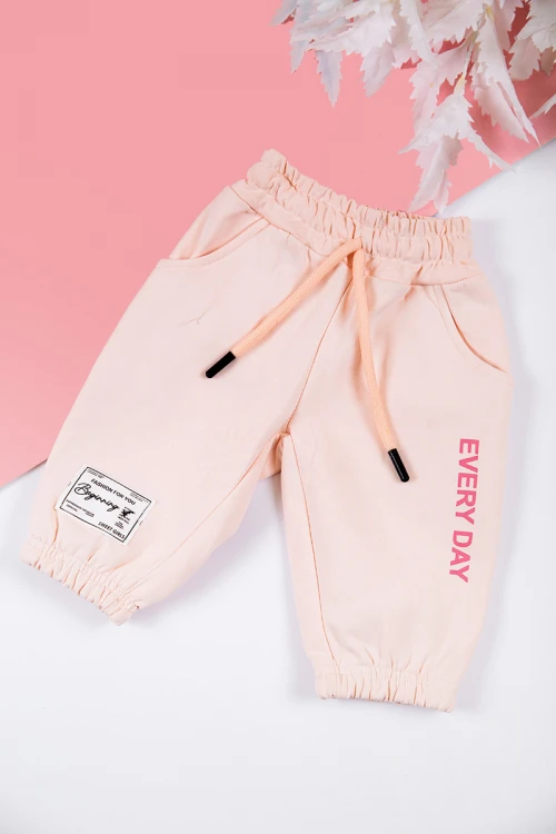 طقم بناتي شتوي قطعتين لون خربزي بكتابات من الأمام و بقبعة رأس  و أكمام طويلة و رباط و زم من الخصر