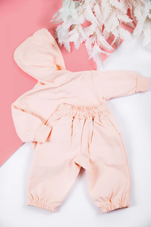 طقم بناتي شتوي قطعتين لون خربزي بكتابات من الأمام و بقبعة رأس  و أكمام طويلة و رباط و زم من الخصر