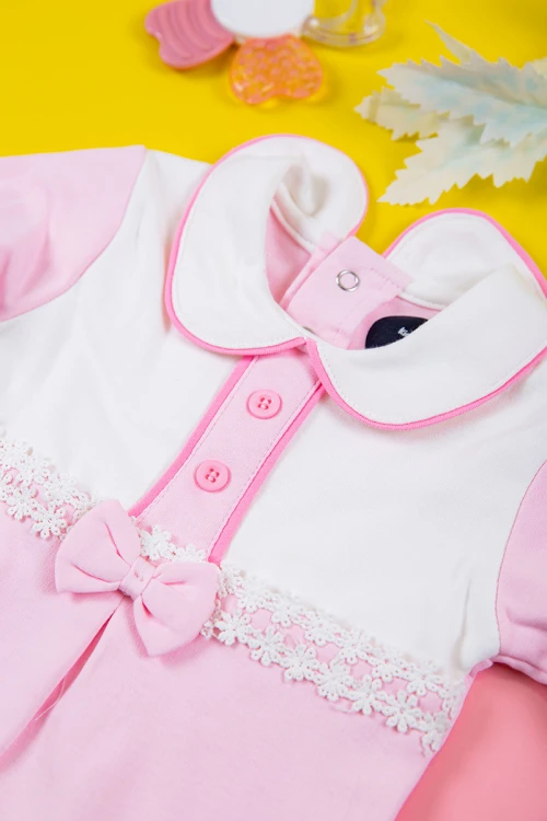 بربتوز بناتي أطفال لون وردي و أبيض مزين بأزرار و فيونكة من الأمام ذو أكمام طويلة و أزرار من الخلف و الأسفل