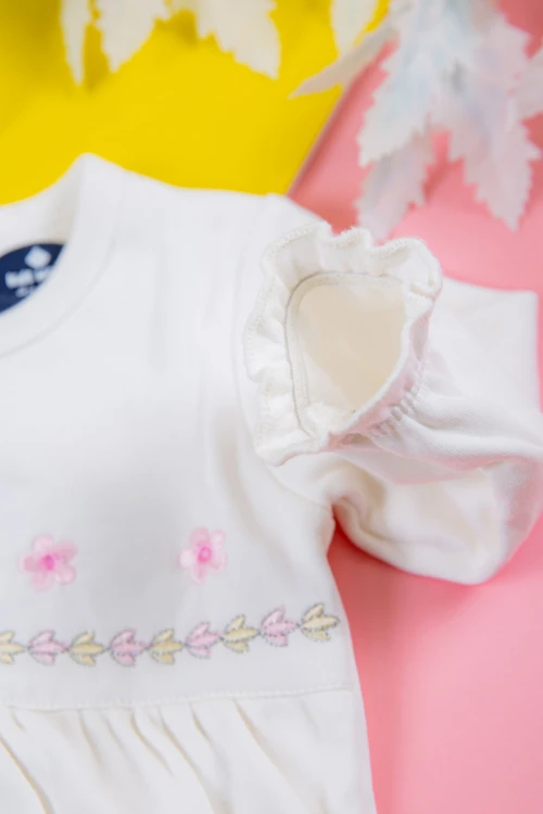 بربتوز بناتي أطفال لون أبيض مزين بزخرفة من الأمام ذو أكمام طويلة بزم و أزرار من الخلف و الأسفل