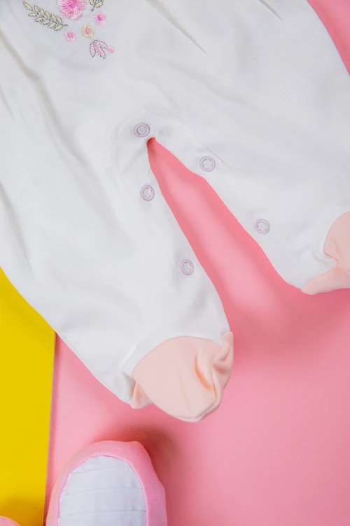 بربتوز بناتي أطفال لون أبيض مزين بزخرفة من الأمام ذو أكمام طويلة بزم و أزرار من الخلف و الأسفل