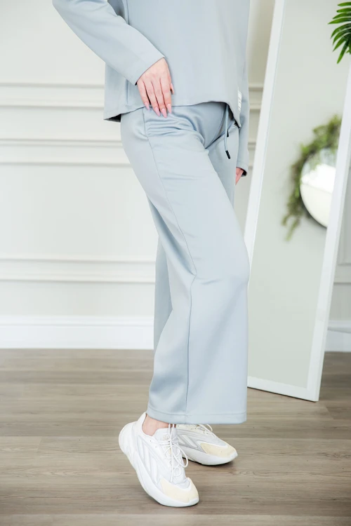 طقم نسائي شتوية قطعتين لون سماوي ذو أكمام طويلة بكتابة و طبعات من الأمام و ببنطلون برباط و زم من الخصر