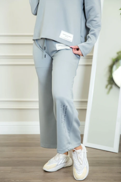 طقم نسائي شتوية قطعتين لون سماوي ذو أكمام طويلة بكتابة و طبعات من الأمام و ببنطلون برباط و زم من الخصر