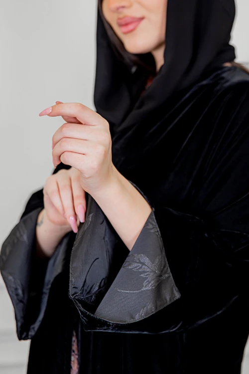 عباية نسائية شتوية أنيقة لون أسود قماش مخمل مزينة من الأكمام و تدخيلات من الجوانب بقماش مشجر و أزرار من الأمام مع طرحة
