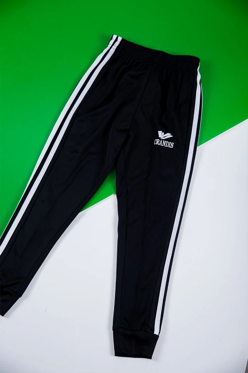 طقم ولادي رياضي قطعتين تيشيرت لون أبيض و أخضر بأكمام قصيرة و بنطلون طويل لون أسود برباط و زم من الخصر و الأسفل