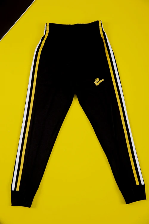 طقم ولادي رياضي قطعتين تيشيرت لون أحمر بأكمام قصيرة و بنطلون طويل لون أسود مخطط باللون الأبيض و الأصفر من الجانبين بزم من الخصر و الأسفل