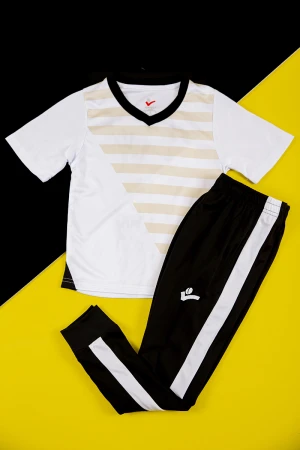 طقم ولادي رياضي قطعتين تيشيرت لون أبيض مخطط باللون البيج بأكمام قصيرة و بنطلون طويل لون أسود مخطط باللون الأبيض من الجانبين بزم من الخصر و الأسفل