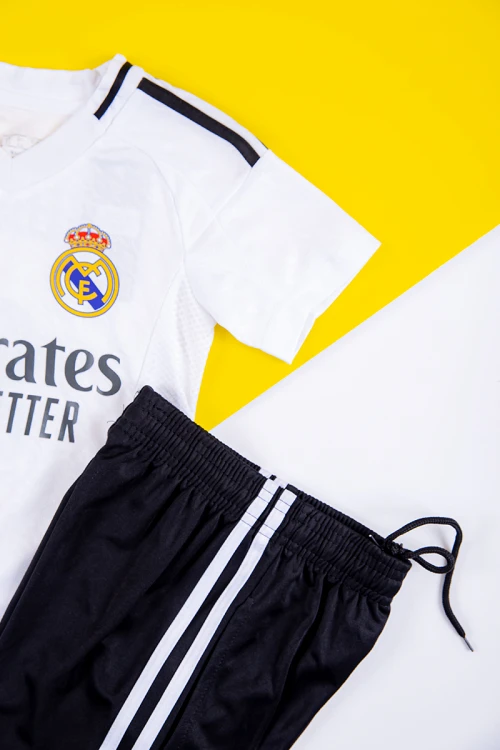 طقم ولادي رياضي قطعتين تيشيرت ريال مدريد بأكمام قصيرة و بنطلون طويل لون أسود مخطط باللون الأبيض من الجانبين بزم من الخصر و الأسفل