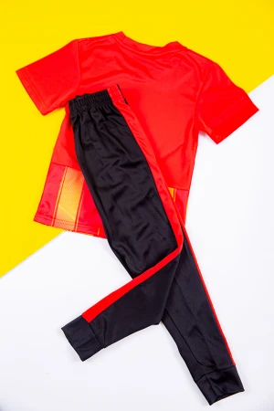 طقم ولادي رياضي قطعتين تيشيرت لون أحمر بطبعات ذهبية ذو أكمام قصيرة و بنطلون طويل لون أسود مخطط باللون الأحمر من الجانبين بزم من الخصر و الأسفل