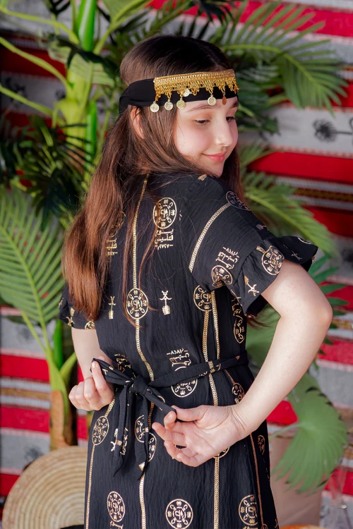 فستان بناتي لون أسود بأكمام قصيرة مزين بطبعات من شعار يوم التأسيس باللون الذهبي و رباط من الخصر