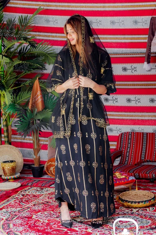 فستان  نسائي تراثي لون أسود بأكمام قصيرة مزين بطبعات من شعار يوم التأسيس باللون الذهبي و رباط من الخصر