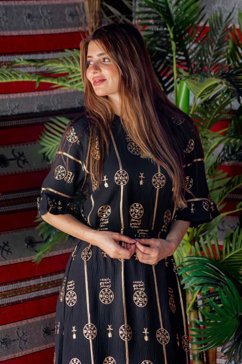 فستان  نسائي تراثي لون أسود بأكمام قصيرة مزين بطبعات من شعار يوم التأسيس باللون الذهبي و رباط من الخصر