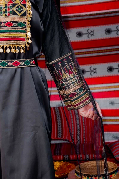 جلابية نسائية تراثية لون أسود بتطريز تراثي ملون من الأمام و الأكمام مزينة بجنيهات من الأمام و برباط في الخصر مع قماش شيفون من الخارج