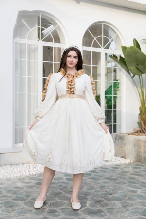 فستان بناتي لون أبيض مزين بكشكشة باللون البيج الغامق من الأكمام و الأمام ذو أكمام طويلة و حزام من الخصر 