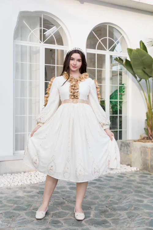 فستان بناتي لون أبيض مزين بكشكشة باللون البيج الغامق من الأكمام و الأمام ذو أكمام طويلة و حزام من الخصر