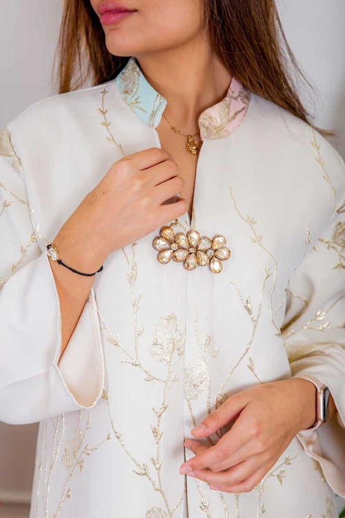 جلابية نسائية لون أبيض بتطريز ذهبي و بتدرجات ألوان من الأسفل ذو ياقة عالية بقصة سبعة مع اكسسوار و أكمام طويلة