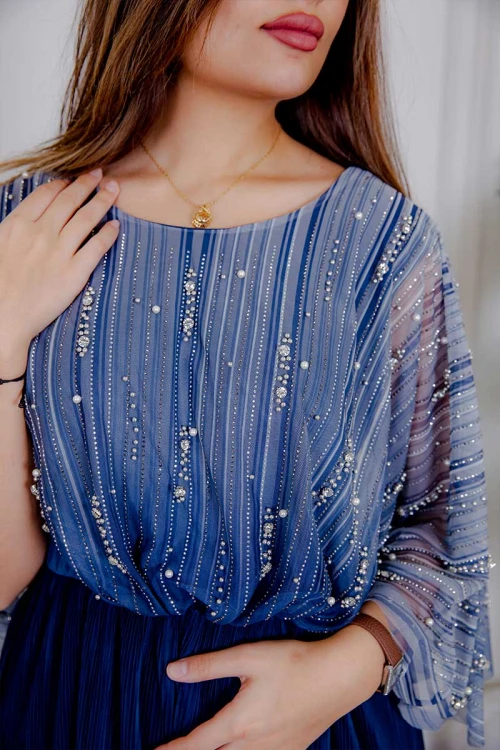 فستان نسائي لون كحلي بتدرجات لونية و قماش شيفون من الأعلى مزين باللؤلؤ و الفصوص و بخصر مزموم