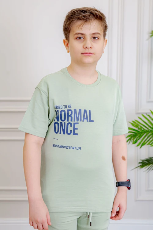 ترنج ولادي قطعتين لون تفاحي تيشيرت بكتابات من الأمام و الخلف و بنطلون بجيوب من الجانبين و الخلف و برباط في الخصر