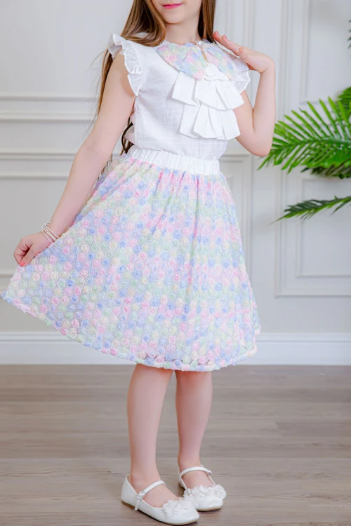 طقم تيور بناتي قطعتين بلوزة بلون أبيض مزينة بفيونكة ملونة من الأمام بدون أكمام و تـنورة ملونة