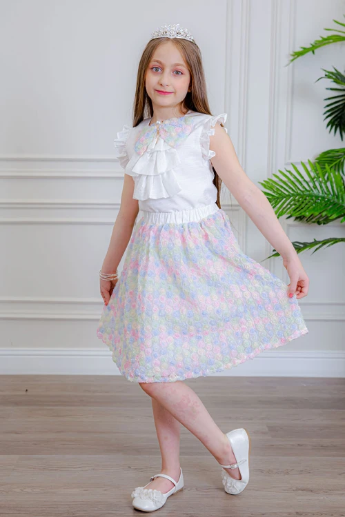 طقم تيور بناتي قطعتين بلوزة بلون أبيض مزينة بفيونكة ملونة من الأمام بدون أكمام و تـنورة ملونة