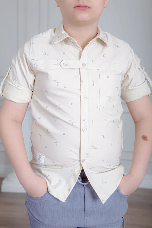 بدلة ولادي قطعتين قميص لون بيج فاتح بأزرار من الأمام و بنطلون لون موف فاتح بجيوب من الجانبين و الخلف