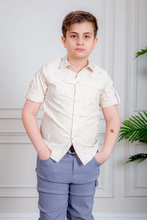 بدلة ولادي قطعتين قميص لون بيج فاتح بأزرار من الأمام و بنطلون لون موف فاتح بجيوب من الجانبين و الخلف 