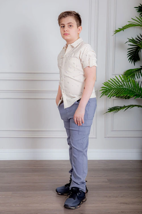 بدلة ولادي قطعتين قميص لون بيج فاتح بأزرار من الأمام و بنطلون لون موف فاتح بجيوب من الجانبين و الخلف