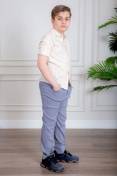 بدلة ولادي قطعتين قميص لون بيج فاتح بأزرار من الأمام و بنطلون لون موف فاتح بجيوب من الجانبين و الخلف