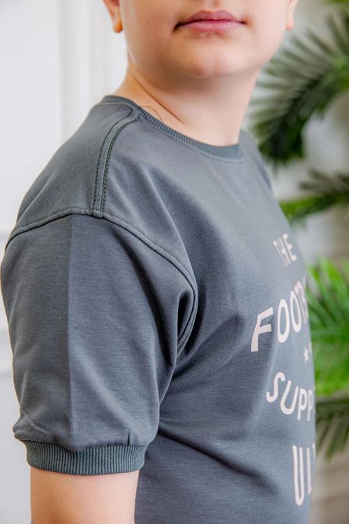 ترنج ولادي قطعتين لون رمادي تيشيرت بكتابات من الأمام و الخلف و بنطلون بجيوب من الجانبين و الخلف