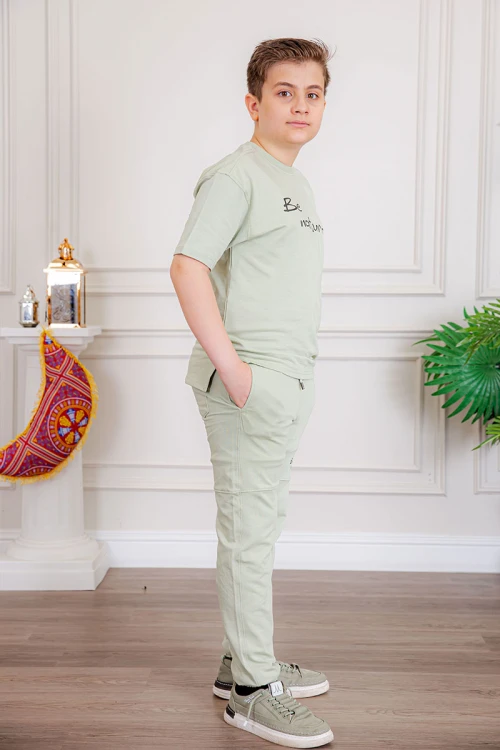 ترنج ولادي قطعتين لون تفاحي تيشيرت بكتابات من الأمام و الخلف و بنطلون طويل بكتابات من الأمام و جيوب من الجانبين و الخلف و رباط في الخصر