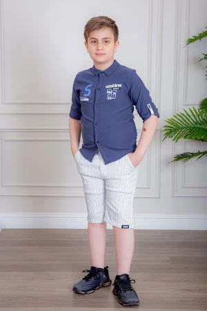 بدلة ولادي قطعتين قميص لون كحلي بأزرار و كتابات من الأمام و شورت لون أبيض مخطط بجيوب من الجانبين و الخلف