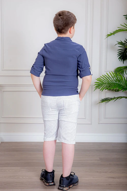 بدلة ولادي قطعتين قميص لون كحلي بأزرار و كتابات من الأمام و شورت لون أبيض مخطط بجيوب من الجانبين و الخلف