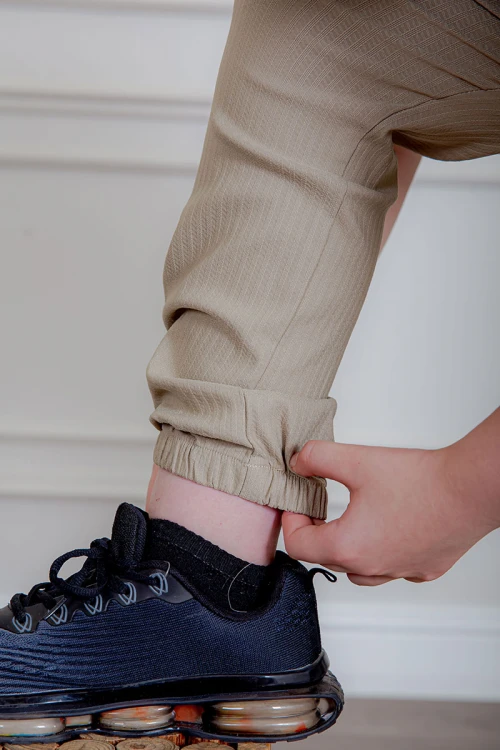 بدلة ولادي قطعتين قميص لون سماوي  بأزرار و جيب و كتابات من الأمام و بنطلون لون بيج بجيوب من الجانبين و الخلف و برباط في الخصر