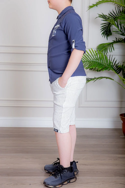 بدلة ولادي قطعتين قميص لون كحلي بأزرار و كتابات من الأمام و شورت لون أبيض مخطط بجيوب من الجانبين و الخلف