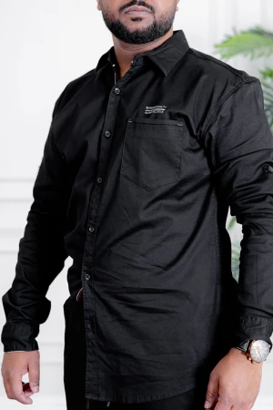قميص رجالي لون أسود بأكمام طويلة و جيب من الأمام و بأزرار من الأمام و الأكمام 