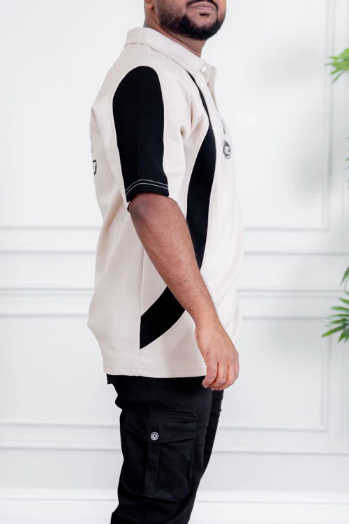 تيشيرت رجالي لون بيج فاتح و أسود ياقة مطوية بأزرار مزين بكتابات و طبعات من الأمام و الخلف