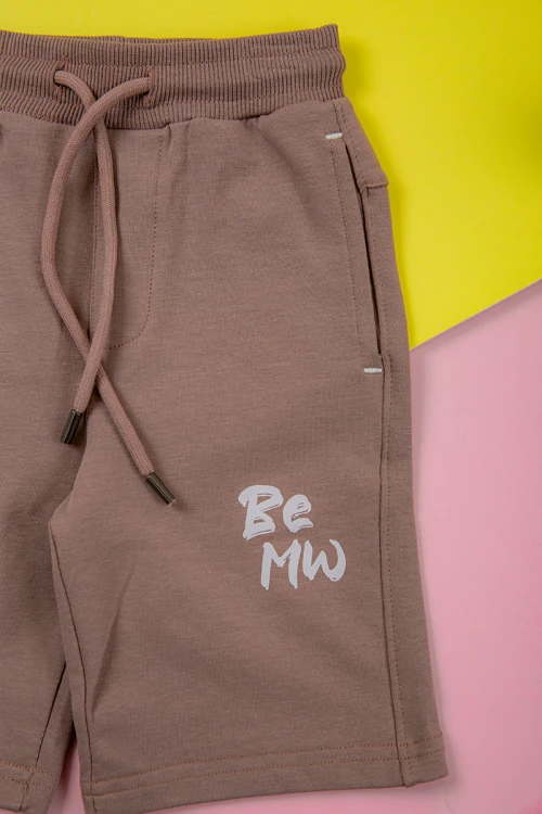 ترنج ولادي قطعتين لون لحمي تيشيرت برسومات و كتابات من الأمام و شورت برباط في الخصر و جيوب من الجانبين و الخلف