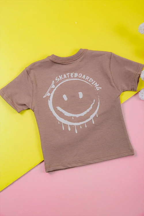 ترنج ولادي قطعتين لون لحمي تيشيرت برسومات و كتابات من الأمام و شورت برباط في الخصر و جيوب من الجانبين و الخلف