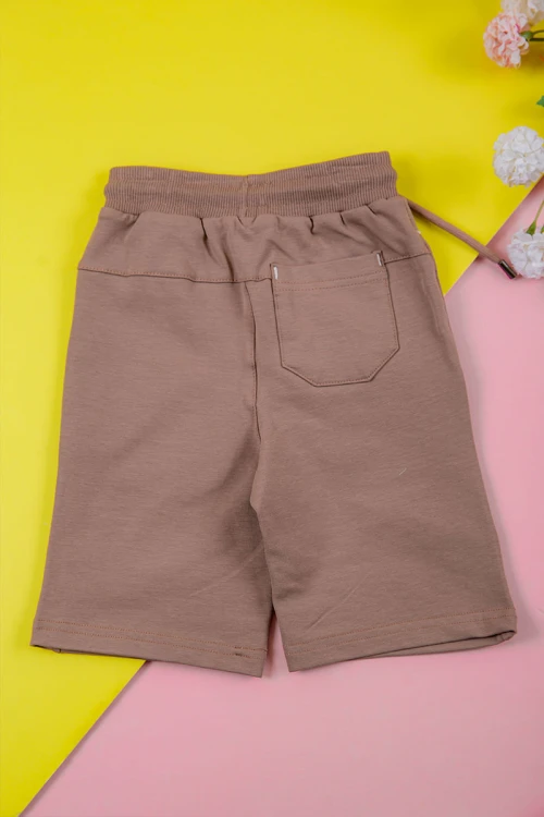 ترنج ولادي قطعتين لون لحمي تيشيرت برسومات و كتابات من الأمام و شورت برباط في الخصر و جيوب من الجانبين و الخلف