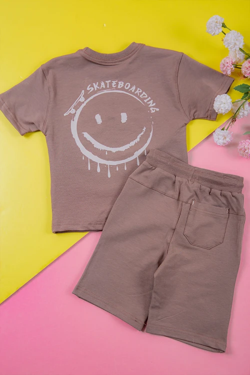ترنج ولادي قطعتين لون لحمي تيشيرت برسومات و كتابات من الأمام و شورت برباط في الخصر و جيوب من الجانبين و الخلف