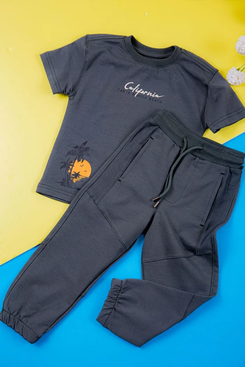 ترنج ولادي قطعتين لون كحلي تيشيرت بكتابات ورسومات من الأمام و بنطلون طويل برباط في الخصر و جيوب من الجانبين و الخلف