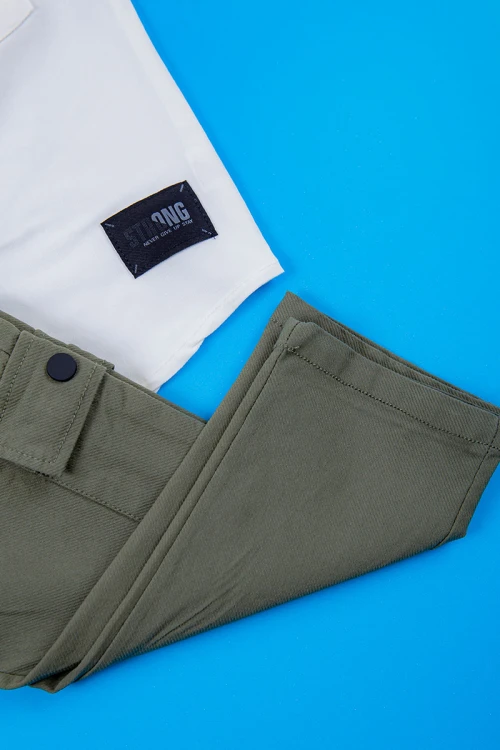 طقم ولادي قطعتين قميص أبيض مشجر باللون السماوي ياقة مطوية و أزرار من الأمام و شورت لون سماوي برباط في الخصر و جيوب من الجانبين