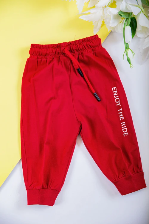 طقم ولادي قطعتين تيشيرت لون أحمر مزين بكتابات و رسومات من الأمام مع بنطلون طويل لون أحمر برباط في الخصر و زم في الأسفل