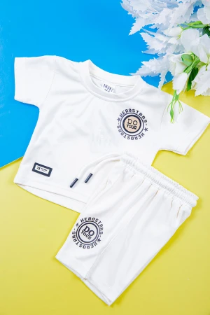 طقم ولادي قطعتين تيشيرت لون أبيض مزين بكتابات و رسومات من الأمام مع شورت لون أبيض برباط في الخصر 