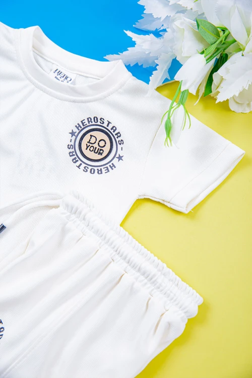 طقم ولادي قطعتين تيشيرت لون أبيض مزين بكتابات و رسومات من الأمام مع شورت لون أبيض برباط في الخصر