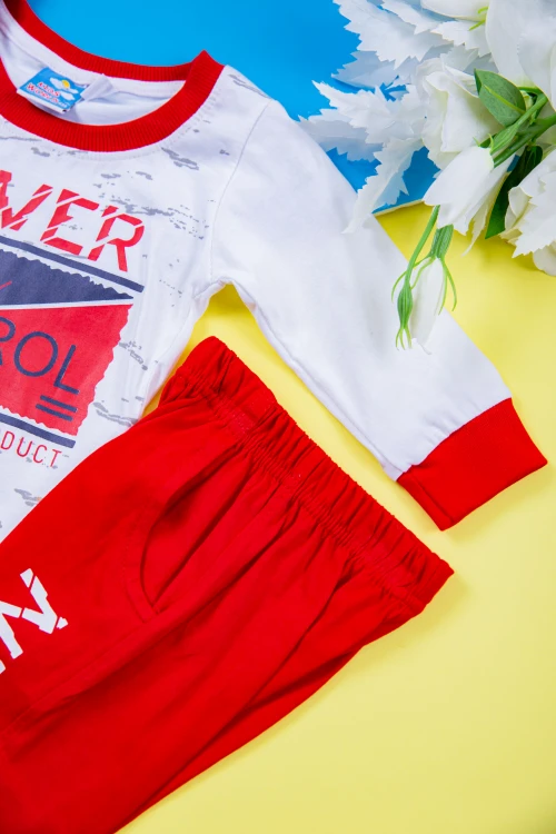 طقم ولادي قطعتين بلوزة لون أبيض مزينة بكتابات و رسومات من الأمام مع بنطلون طويل لون أحمر بكتابات و جيوب من الجانبين و زم في الأطراف